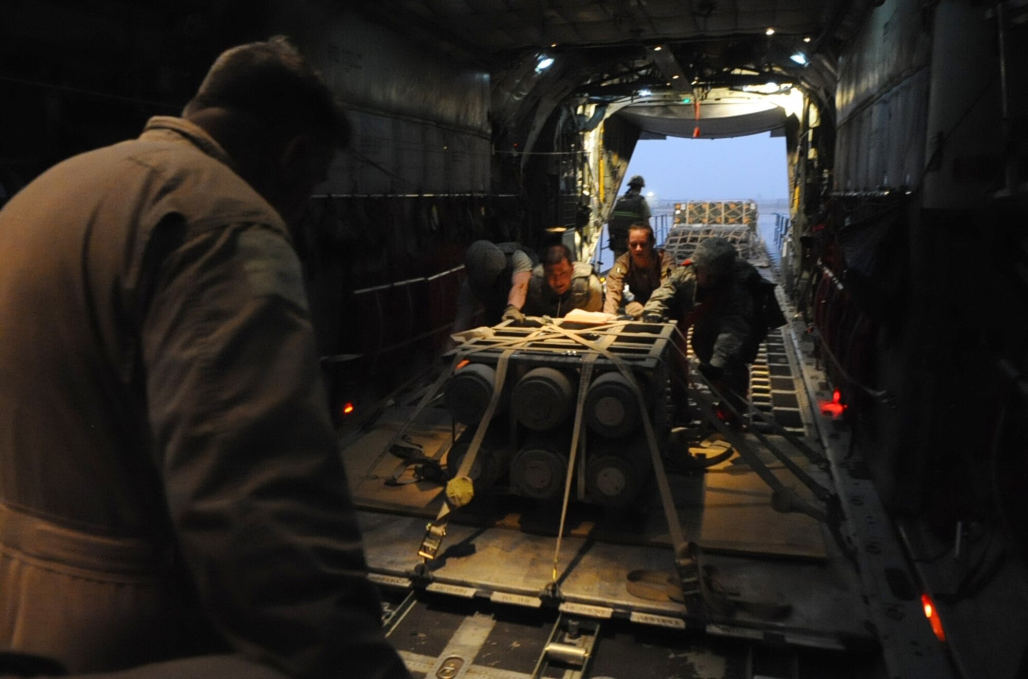 Senior Master Sgt. Steve Tarrance (left), 746th Expeditionary Airlift Squadron loadmaster, monitors as Airmen push a pallet into place on a C-130 Hercules at Joint Base Balad, Iraq, June 23, 2010. (U.S. Air Force photo by Senior Airman Kasey Zickmund)
