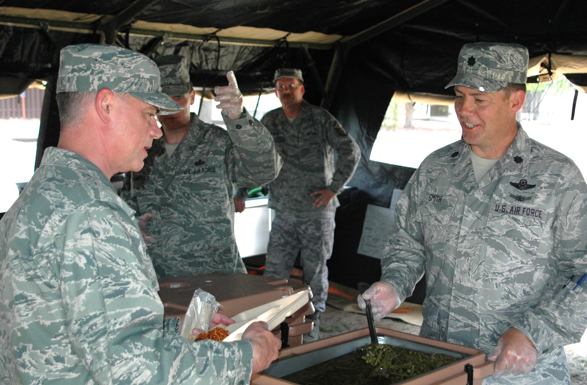 Col. Jay Pittman, Jr. (left), 302nd Airlift Wing commander, gets served a helping of green beans from Lt. Col. Michael Smith, 302 Services Flight commander during a June 6 visit from the commander of 22nd Air Force, Maj. Gen. James T. Rubeor. General Rubeor visited the 302nd AW during its June Unit Training Assembly weekend to get a first-hand look at the many missions the wing supports. The 302nd AW is a subordinate unit to 22nd AF. (U.S. Air Force photo/Tech. Sgt. Daniel Butterfield)