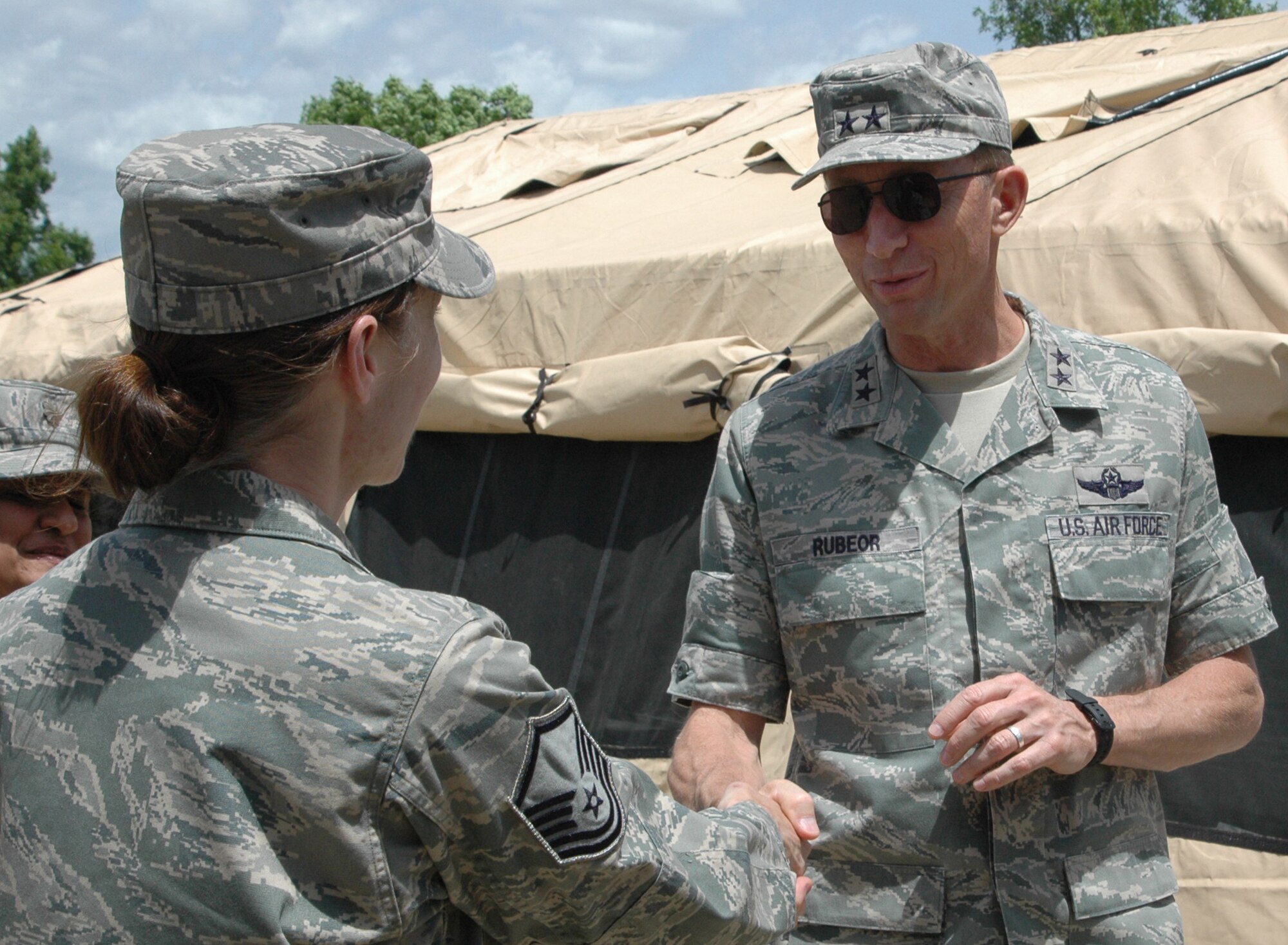 Maj. Gen. James T. Rubeor (right) shakes hands June 6 with Master Sgt. Vicki Robertson, 302nd Airlift Wing staff judge advocate non-commissioned officer in charge, after seeing the 302nd Services Flight's single palletized expeditionary kitchen, or SPEK. General Rubeor, 22nd Air Force commander, visited the 302nd AW during the June Unit Training Assembly weekend to get a first-hand look at the many missions the wing supports. The 302nd AW is a subordinate unit to 22nd AF. Sergeant Robertson is the 302nd AW's senior NCO of the year for 2009. (U.S. Air Force photo/Tech. Sgt. Daniel Butterfield) 