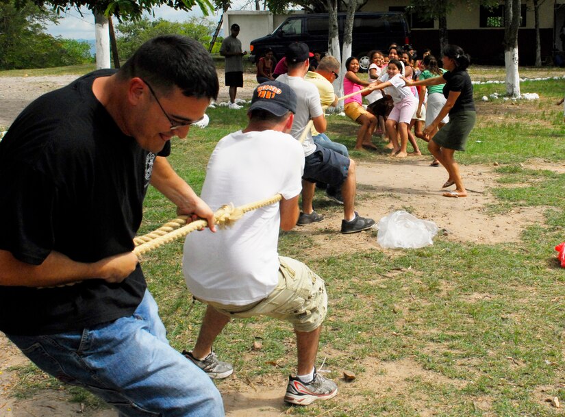 COMAYAGUA, Honduras --  Tech. Sgt. Kirk Withycombe, of the 612th Air Base Squadron, moves back with all his weight as he and three other members of the 612th ABS slowly lose ground in a tug-of-war match against 15 kids from the Nuestra Señora de Guadalupe orphanage here Friday, July 9. During their visits to the orphanage each month, the 612th ABS brings an assortment of outdoor games to play with the children. (U.S. Air Force photo/Tech. Sgt. Benjamin Rojek)