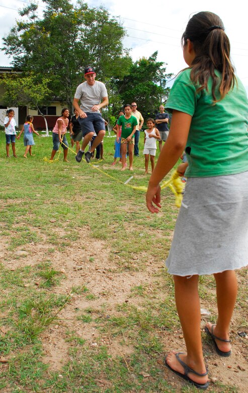 COMAYAGUA, Honduras --  Counting as he jumps, Airman 1st Class Zachary Parker, of the 612th Air Base Squadron, plays a jump rope game with the children from the Nuestra Señora de Guadalupe orphanage here Friday, July 9. Instead of only dropping off gifts, the members of the 612th ABS who visit the orphange bring outdoor games to play with the children. (U.S. Air Force photo/Tech. Sgt. Benjamin Rojek) 