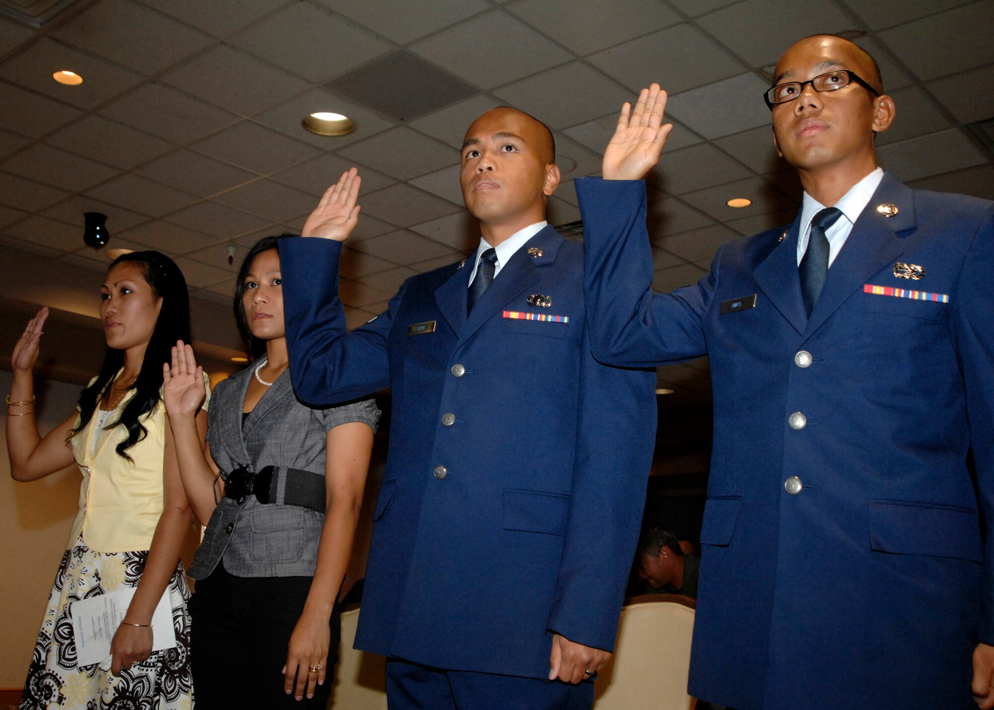 (From left to right) Bernadett Wheeldon, Johanna Eighinger, Airman 1st Class Joel Sipin, 27th Special Operations Contracting Squadron and Airman Nimol Mao, 27th Special Operations Logistics Readiness Squadron, prepare to take the citizenship oath during naturalization ceremonies. The Airmen and family members were sworn in by Immigration Service Officer Peter Rechkemmer from Albuquerque, N.M., July 10, 2010, at The Landing Zone at Cannon Air Force Base, N.M. (U.S. Air Force photo by Greg Allen) (RELEASED)