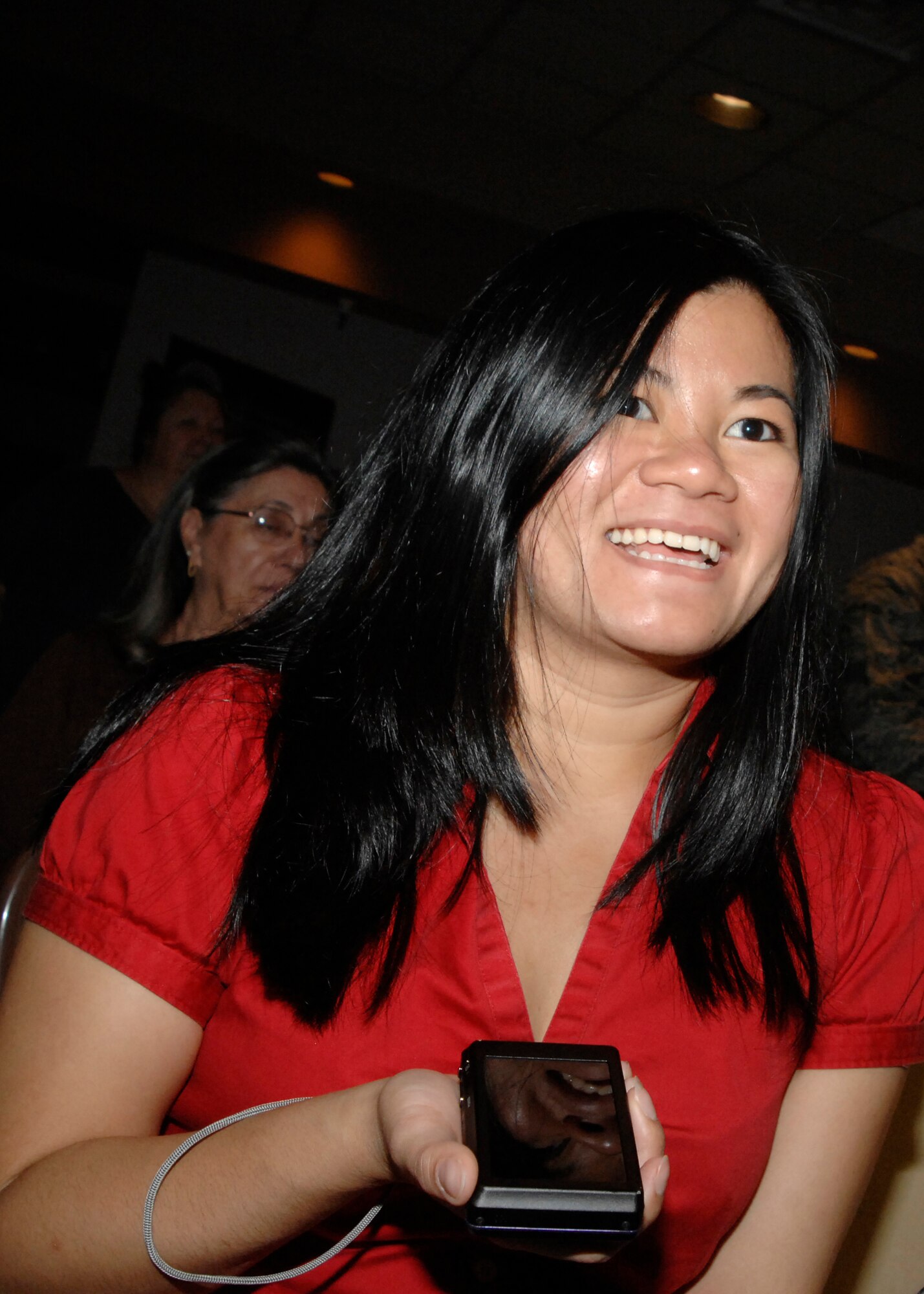Maria-Jaine Sipin smiles as her husband, Airman 1st Class Joel Sipins, 27th Special Operations Contracting Squadron, becomes a United States citizen during ceremonies at The Landing Zone, July 8. Mrs. Sipin also works for 27th SOCONS. (U.S. Air Force photo by Greg Allen) (RELEASED)