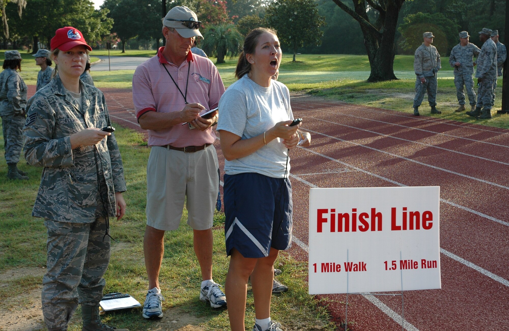 Maj. Christina R. Liegl encourages Airmen performing their 1.5 mile run during their bi-annual physical assessment at 7:30 a.m. on July 11, 2010 at the base track here. New PT standards took effect July 1, 2010 and all Airmen will need a minimum composite score of 75. Results will fall into one of three categories: 90 and above, excellent; 75-90, satisfactory; and under 75, unsatisfactory. Maj. Liegl is a 315 AW flight safety officer and fitness program manager. (U.S. Air Force photo/Staff Sgt. Shane Ellis)