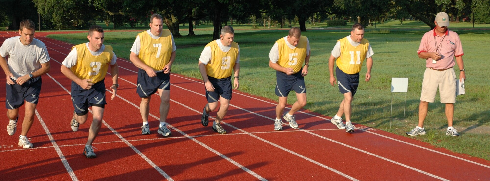 Airmen from the 315th Airlift Wing take off for their 1.5 mile run during their bi-annual physical assessment at 7:30 a.m. on July 11, 2010 at the base track here. New PT standards took effect July 1, 2010 and all Airmen will need a minimum composite score of 75. Results will fall into one of three categories: 90 and above, excellent; 75-90, satisfactory; and under 75, unsatisfactory. (U.S. Air Force photo/Staff Sgt. Shane Ellis)
