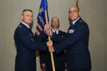 MINOT AIR FORCE BASE, N.D. -- Presiding officer Col. Walter Lindsley, 498th Nuclear Systems Wing commander at Kirtland AFB, N.M., passes the ceremonial flag to Col. Phillip Boroff, 798th Munitions Maintenance Group commander, traditionally signifying the assumption of command over the 798th MUMG here July 12. The 798th MUMG standup is an important step toward establishing support for Air Force Global Strike Command, which is the lead major command for Air Force nuclear operations. (U.S. Air Force photo by Airman 1st Class Aaron-Forrest Wainwright)