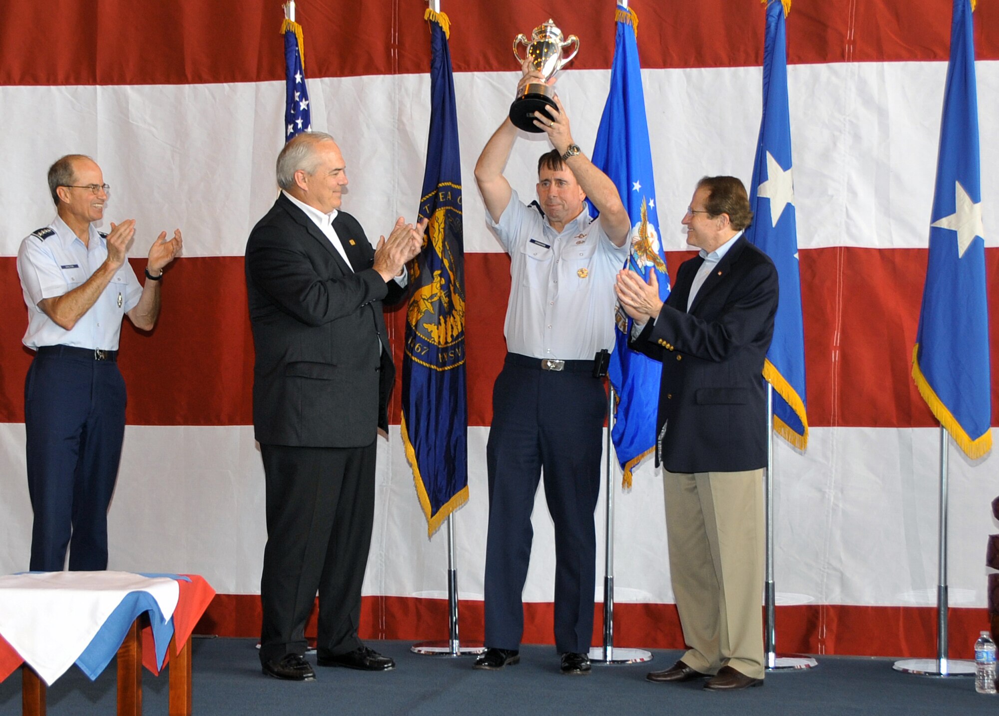 OFFUTT AIR FORCE BASE, Neb. - 55th Wing Commander, Brig. Gen. John N.T. Shanahan, celebrates July 7 at the Bennie Davis Maintenance Facility after accepting the Omaha Trophy for strategic aircraft operations on behalf of all Fightin' Fifty Fifth members. The Omaha Trophy is awarded annually to four military units demonstrating the highest performance standards in U.S. Strategic Command mission areas, according to the command. U.S. Air Force photo by Jeff W. Gates.