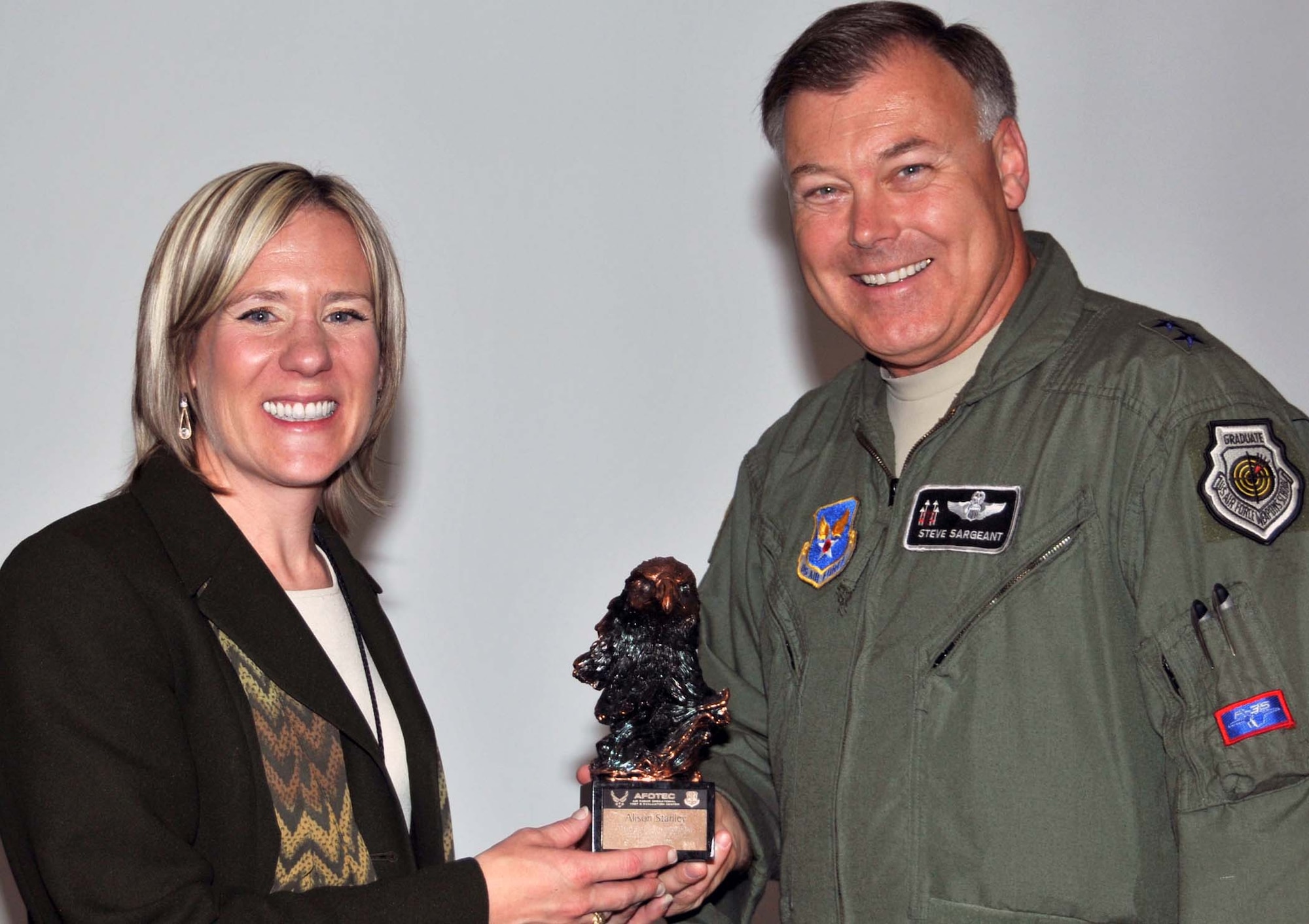 Maj. Gen. Stephen T. Sargeant, Air Force Operational Test and Evaluation Center commander, presents a token of appreciation to Alison Stanley, Presbyterian Healthcare Services Director of Operations for the Process Excellence Department, for being a guest speaker at the June 25 AFOTEC Commander’s Conference. Ms. Stanley shared lessons learned and best practices using Lean Six Sigma to improve effectiveness and efficiency and eliminate waste.  U.S. Air Force Photo by George Diamond.