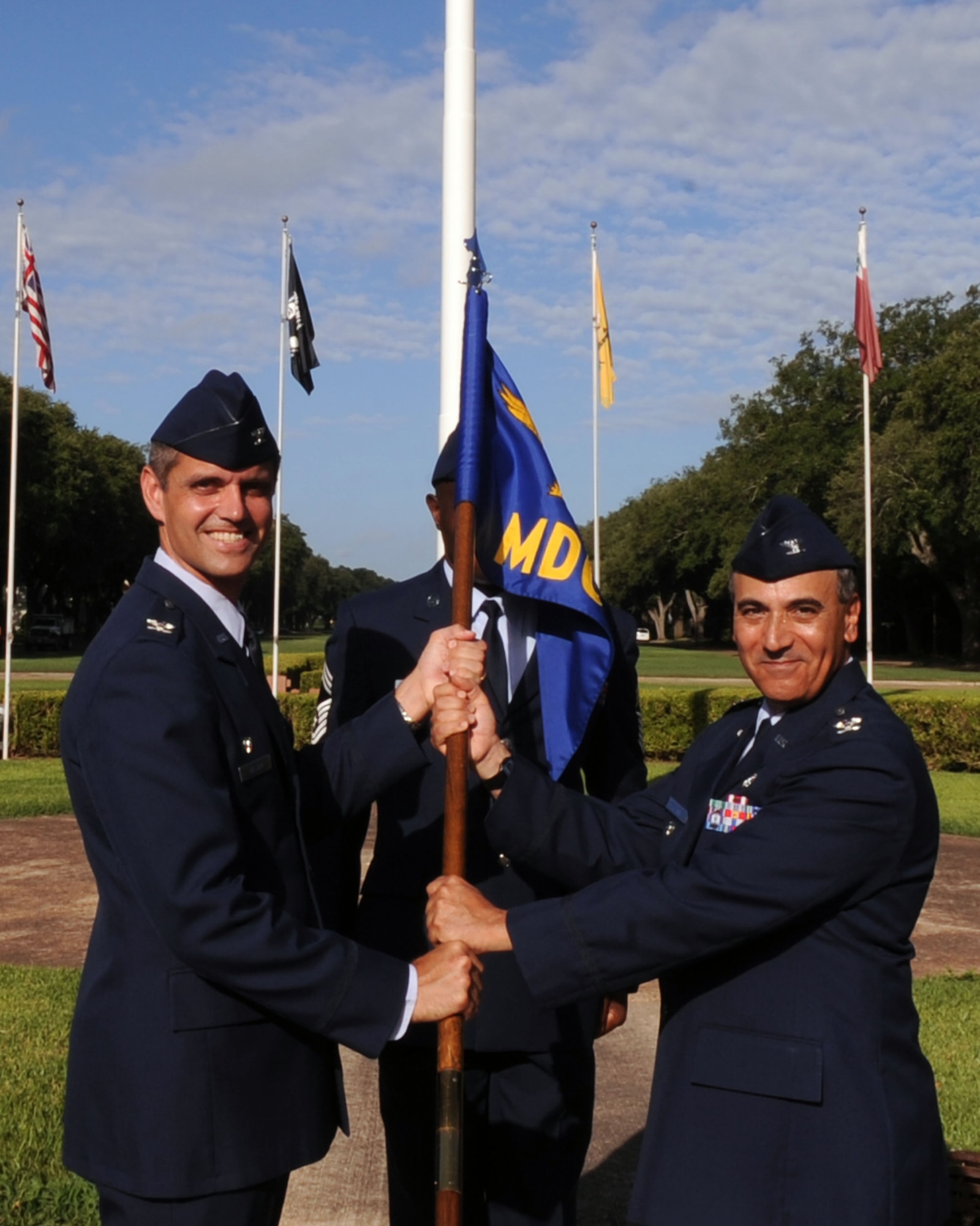 BARKSDALE AIR FORCE BASE, La. – Col. Steven L. Basham (left), 2d Bomb Wing commander, presents the unit guidon to Col. Paul M. Fortunato July 7. Colonel Fortunato assumed command of the 2d Medical Group from Col. Thomas W. Grace. The passing of command is one deeply rooted in military tradition, dating back to the Norman Conquest of England. It serves as a visible means of handing the reins of command to the new commander. As the unit flag or guidon is exchanged, it represents the responsibility associated with the unit being surrendered and accepted. (U.S. Air Force photo by Senior Airman La’Shanette V. Garrett) (RELEASED)