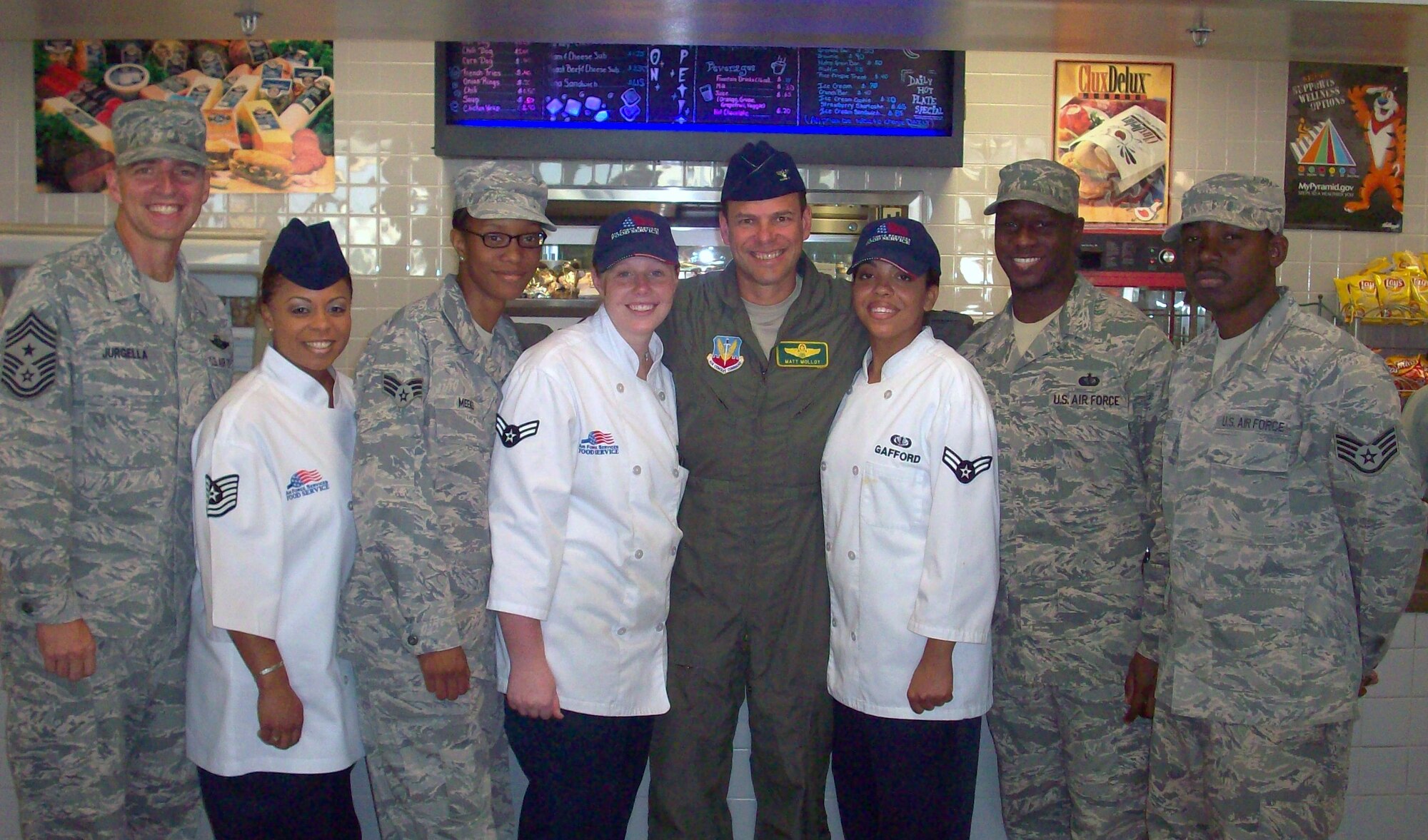 LANGLEY AIR FORCE BASE, Va. -- Chief Master Sgt. Kevin Jurgella, 1st Fighter Wing command chief (far left), and Col. Matt Molloy, 1 FW commander (center), join the team at the Raptor Cafe July 6. Colonel Molloy and Chief Jurgella called working alongside the foodservice pros "a great experience." (Photo courtesy/Tech Sgt. Lisette Spencer)