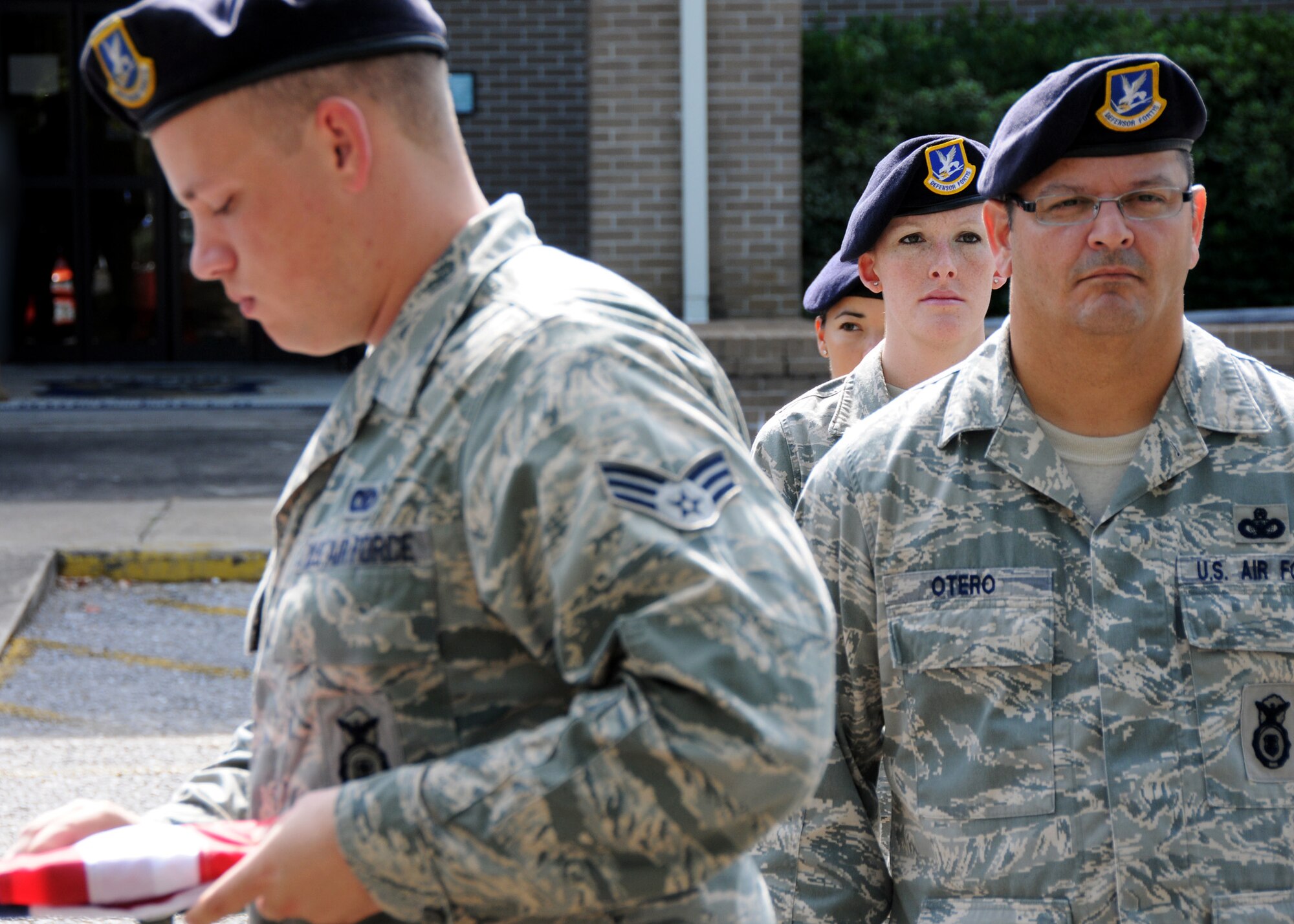 Members of the 919th Security Forces Squadron, stand at attention while the flag is being folded during a practice of a flag-raising ceremony July 11 at Duke Field. (U.S. Air Force photo/Tech. Sgt. Samuel King Jr.)