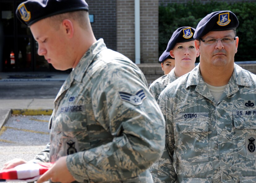 Members of the 919th Security Forces Squadron, stand at attention while the flag is being folded during a practice of a flag-raising ceremony July 11 at Duke Field. (U.S. Air Force photo/Tech. Sgt. Samuel King Jr.)