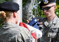 Senior Airman Zachary Mabes, 919th Security Forces Squadron, holds the rope while another Airman unhooks the flag while practicing a flag-raising ceremony July 11 at Duke Field. (U.S. Air Force photo/Tech. Sgt. Samuel King Jr.)
