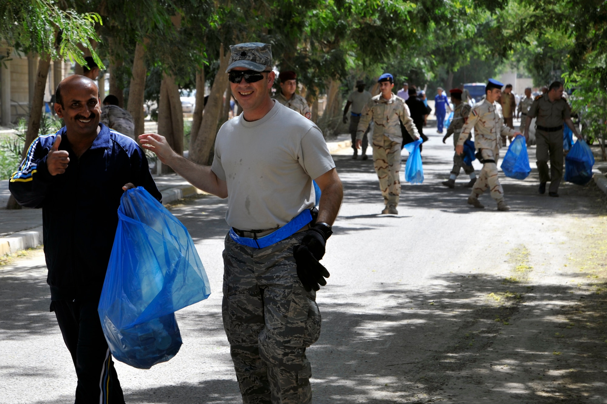 Lt. Col. Rob Pata, director of logistics, 321st Air Expeditionary wing, helps Iraqi airmen clean up their base during a base clean-up June 22, 2010, at Hawk Base, Iraq. Iraqi and U.S. Air Force Airmen recently joined for the inaugural Iraqi air force labor day to help beautify the base and strengthen their partnership. (U.S. Air Force photo by Senior Airman Perry Aston) (Released)
