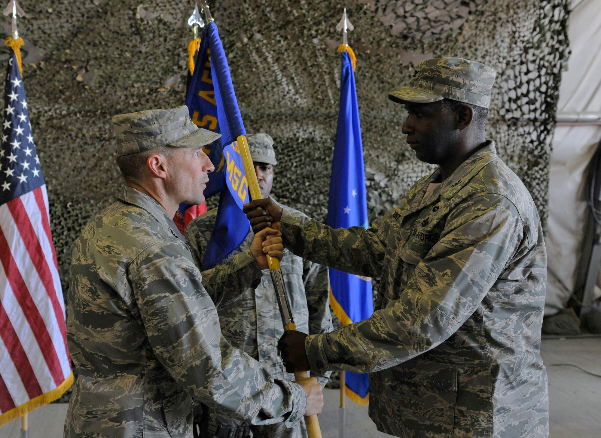 Col. Jeffrey Hunt, 455th Expeditionary Mission Support Group commander, receives the 455th EMSG guide on from Brig. Gen. Jack Briggs, then Colonel, 455th Air Expeditionary Wing commander, during the 455th EMSG change of command ceremony at Bagram Airfield, Afghanistan, July 9, 2010. (U.S. Air Force photo/Staff Sgt. Christopher Boitz)