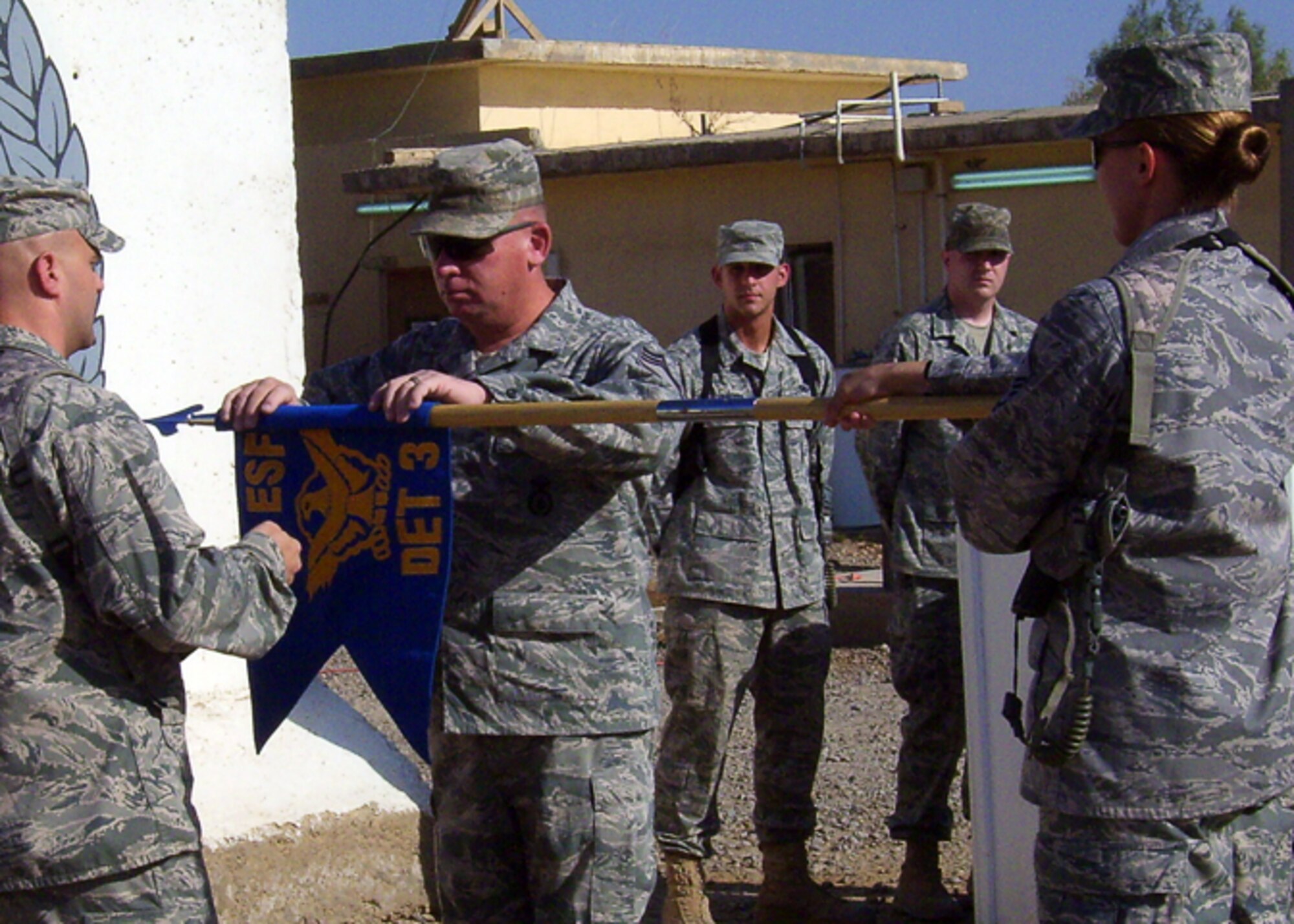 Chief Master Sgt. Tim Ryan, 732nd Expeditionary Security Forces Squadron, Detachment 3, superintendent, rolls up the detachment's flag during the inactivation ceremony at Camp Taji, Iraq, July 3, 2010. Det. 3 has had security forces Airmen rotate through yearly, training Iraqi Police in the Baghdad area since 2006 as a police transition team to help put civil law and order in the hands of civil authorities opposed to having the Iraqi army in Baghdad. (Photo courtesy of the 732nd ESFS, Det. 3 / Released) 