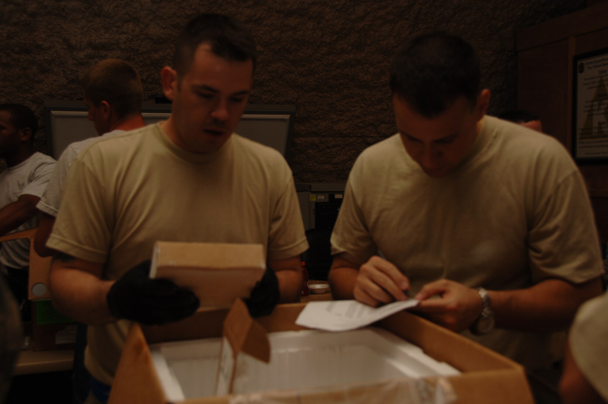 SOUTH WEST ASIA -- (left) Staff Sgt. Jeffrey Zell, 379th Expeditionary Maintenance Squadron, and SrA Aaron Belangeri, 609th Combined Air Operations Center, verify blood products at the 379th Expeditionary Medical Group Blood Transshipment Center at an undisclosed location in Southwest Asia July 10. The center distributes blood products used in theater. (U.S. Air Force photo/Tech. Sgt Kimberly Spinner)