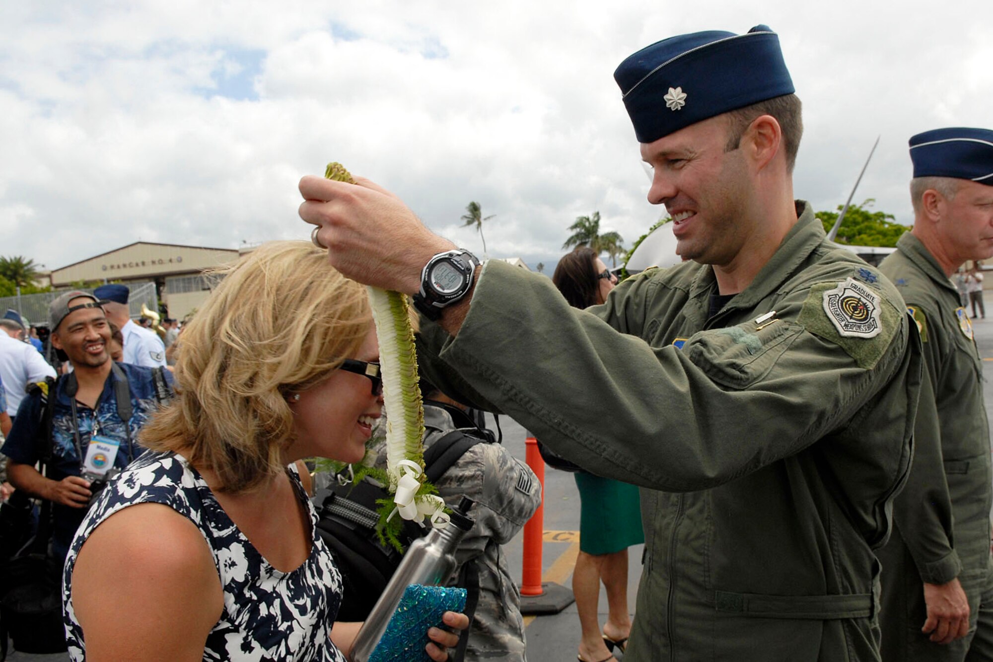 Lt. Col. Harvey "Banger" Newton, pilot 19th Fighter Squadron, places a Hawaiian lei on his wife after the F-22 Raptor Arrival Ceremony at Joint Base Pearl Harbor-Hickam, Hawaii, July 9, 2010. The arrival of the F-22 Raptor marks the beginning of a new associate unit between the Hawaii Air National Guard and the 15th Wing, active duty Air Force. The Raptor represents an exponential leap in warfighting capabilities for U.S. forces in the Pacific. (U.S. Air Force photo/Tech Sgt. Jerome S. Tayborn)
