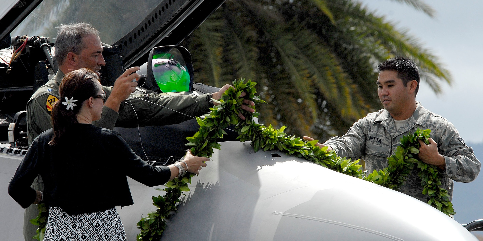 Lt. Col. Harvey "Banger" Newton, pilot 19th Fighter Squadron, along with his wife and Staff Sgt. Ben Nitta, an Hawaii Air National Guard F-22 Raptor crew chief, drapes a maile lei across the nose of the F-22 Raptor during the F-22 Arrival Ceremony July 9, 2010, on Joint Base Pearl Harbor-Hickam, Hawaii. Maile lei is part of a Hawaiian tradition used to mark important occasions. The arrival of the F-22 Raptor marks the beginning of a new associate unit between the Hawaii Air National Guard and the 15th Wing, active duty Air Force.  The Raptor represents an exponential leap in warfighting capabilities for U.S. forces in the Pacific. (U.S. Air Force photo/Tech Sgt. Jerome S. Tayborn)