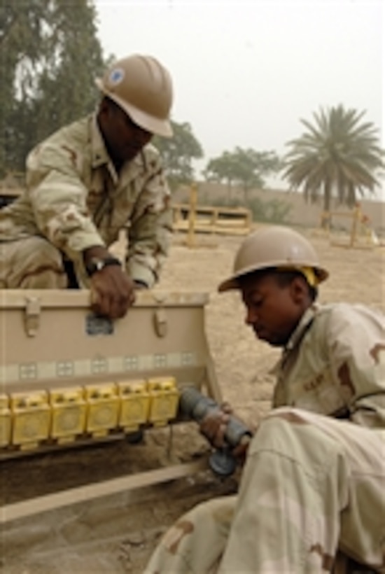 U.S. Navy Petty Officer 2nd Class Robinson Inchiparambil (left) and Petty Officer Ronnel J. Philpott, both Seabees assigned to Naval Mobile Construction Battalion 21, set up power for the team's improvised work area in Baghdad, Iraq, on June 7, 2010.  