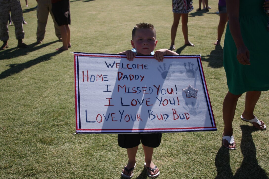 MARINE CORPS AIR GROUND COMBAT CENTER TWENTYNINE PALMS, Calif.--Braiden Dospital, the son of Staff Sgt. Nicholas Dospital, proudly holds up a sign as he awaits his father's arrival from deployment at Del Valle softball field Tuesday. The Battalion Landing Team 1st Bn. 7th Marine Regiment is coming home from the 31st Marine Expeditionary Unit.