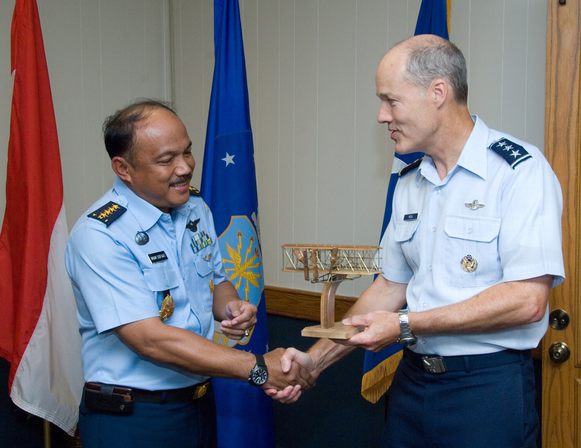 Lt. Gen. Allen Peck hands a model of the Wright Flyer to Air Chief Marshal Imam Sufaat July 12, 2010 at Maxwell Air Force Base, Ala., upon his induction into the Air University international honor roll. The first plane to fly on the site that is now home to Air University was the Wright Brothers' aircraft in 1910. General Peck is the commander of Air University, and Air Chief Marshal Sufaat is the Indonesian air force chief of staff. (U.S. Air Force photo/Melanie Rodgers Cox)