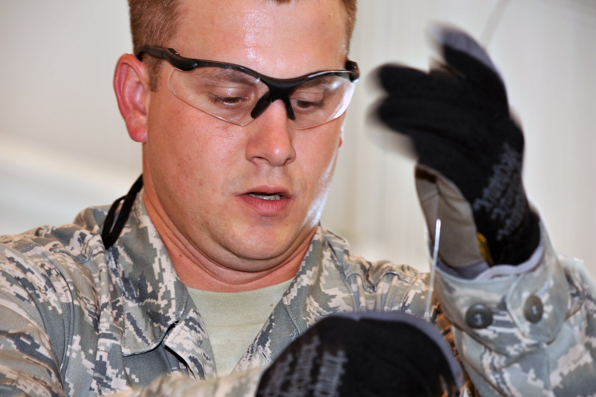 WHITEMAN AFB, Mo. - Staff Sgt. Matthew Biernbaum, 131st Bomb Wing, pulls a wire used to install an arming device into a 500-pound MK-82 bomb, Jul. 12. Sergeant Biernbaum assisted his six teammates in building each of the 12 bombs during the practice session. 