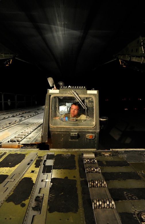 CAMP MARMAL, MAZAR-I-SHARIF, Afghanistan – Tech. Sgt. Lee Fletcher, 621st Contingency Response Wing aerial port team chief, watches from the control cab of a Tunner 60K cargo loader as he is guided into position at the rear loading platform of a C-5B Galaxy transport aircraft at Camp Marmal, Afghanistan July 1.  Sergeant Fletcher and his unit are deployed from Joint-Base McGuire-Dix-Lakehurst, NJ, and are providing temporary cargo handling capability in support of the presidentially-directed surge of manpower and equipment into Afghanistan. (U.S. Air Force photo/Tech. Sgt. Parker Gyokeres/released)