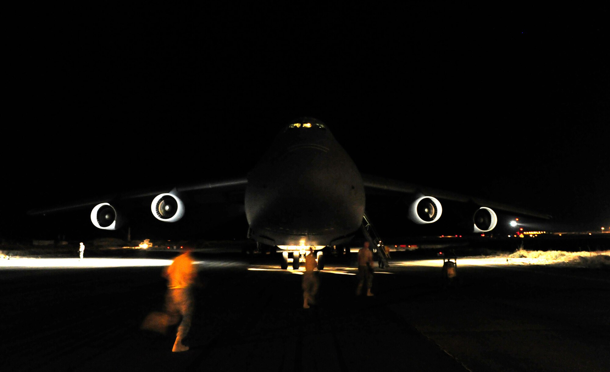 CAMP MARMAL, MAZAR-I-SHARIF, Afghanistan – Aircraft mechanics assigned to the 621st Contingency Response Wing from Joint-Base McGuire-Dix-Lakehurst, NJ, run towards a newly-arrived C-5B Galaxy transport at Camp Marmal, Afghanistan July 1.  The mobility Airmen were deployed to provide temporary aerial-port capability in support of the presidentially-directed surge of manpower and equipment into Afghanistan. (U.S. Air Force photo/Tech. Sgt. Parker Gyokeres/released)