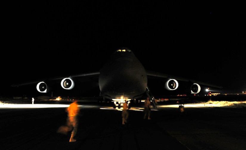 CAMP MARMAL, MAZAR-I-SHARIF, Afghanistan – Aircraft mechanics assigned to the 621st Contingency Response Wing from Joint-Base McGuire-Dix-Lakehurst, NJ, run towards a newly-arrived C-5B Galaxy transport at Camp Marmal, Afghanistan July 1.  The mobility Airmen were deployed to provide temporary aerial-port capability in support of the presidentially-directed surge of manpower and equipment into Afghanistan. (U.S. Air Force photo/Tech. Sgt. Parker Gyokeres/released)