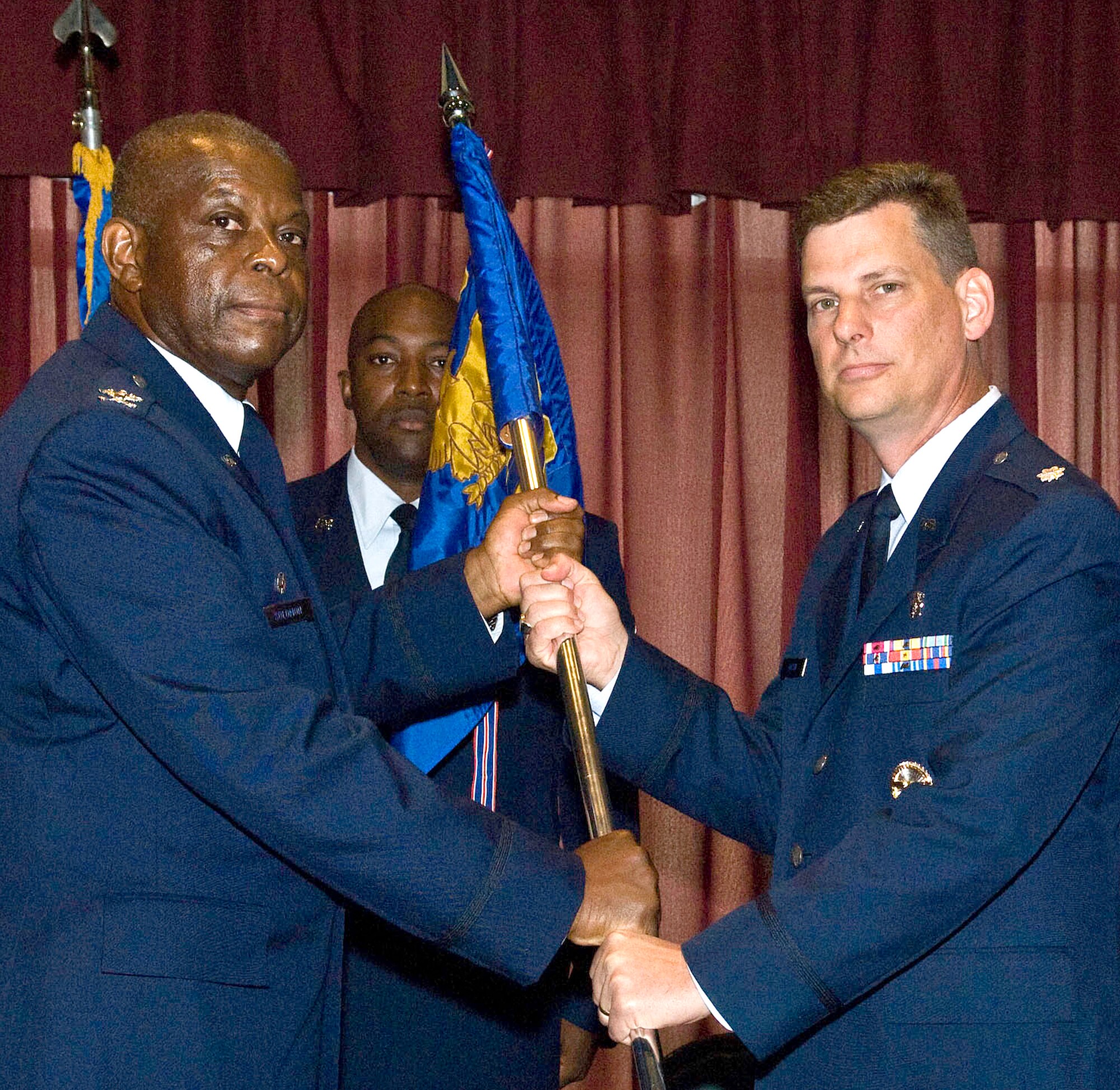Lt. Col. Thomas Bacon, right, accepts command of the 71st Medical Operations Squadron at Vance AFB from Col. (Dr.) Otha L. Solomon Jr., the 71st Medical Group commander, during a ceremony held July 8 at the Vance Collocated Club. Colonel Bacon came to Vance from the TriCare Management Activity at Falls Church, Va. He replaces Lt. Col. Royce “Bull” Terry, who was reassigned to the 6th Medical Group at MacDill AFB, Fla. Behind Colonels Solomon and Bacon is Master Sgt. Mitchell Lawrence, the 71st MDOS superintendent. (U.S. Air Force photo/ Terry Wasson)