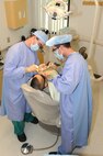 WHITEMAN AIR FORCE, Mo. -Capt. Carl Bhend (left), 509th Medical Group dental clinic dentist is assited by Airman Basic Kenneth Mason (right) , to remove a wisdom tooth from the patient, July 9. (U.S. Air Force photo/ Senior Airman Carlin Leslie)
