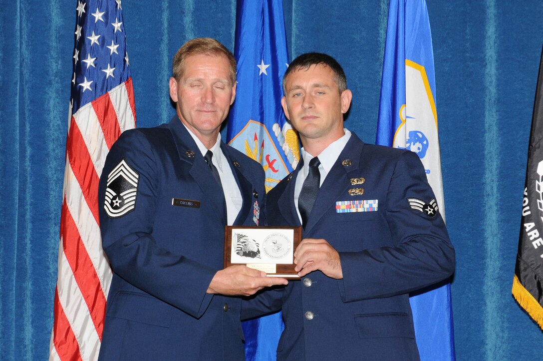 McGHEE TYSON AIR NATIONAL GUARD BASE, Tenn. - Senior Airman Jeremy S. Nagy, a member of the 270th Engineering Installation Squadron, Pennsylvania Air National Guard, right, receives the distinguished graduate award for Airman Leadership School Class 10-4 at The I.G. Brown Air National Guard Training and Education Center here from Chief Master Sgt. Carl E. Collins, a chief enlisted manager at 1st Air Force, Tyndall AFB, Fla., July 2, 2010.  The distinguished graduate award is presented to students in the top ten percent of the class.  It is based on objective and performance evaluations, demonstrated leadership, and performance as a team player.   (U.S. Air Force photo by Master Sgt. Kurt Skoglund/Released)