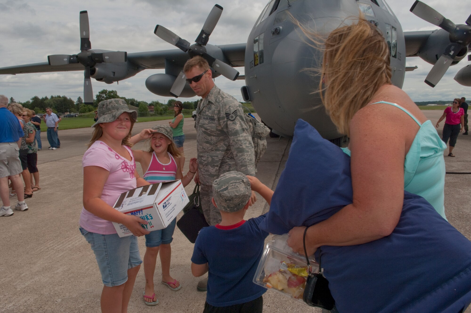 Friends and family excitedly greet Airmen disembarking from a C-130 "Hercules" at the Minneapolis-St. Paul International airport on July 11, 2010. The military cargo aircraft and about twenty Airmen are the first in a series of returns from Afghanistan during July for the 133rd Airlift Wing in 2010. USAF official photo by Senior Master Sgt. Mark Moss