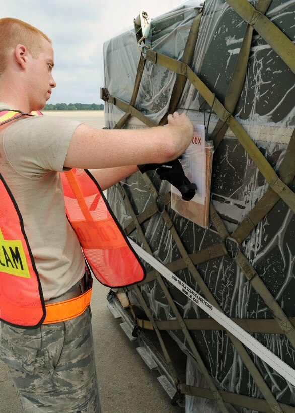 LANGLEY AIR FORCE BASE, Va. – Airmen 1st Class Jason Cox, 633d Logistics Readiness Squadron marshalling and load team (MALT) member, removes pallet identifiers during a Cargo Deployment Function war day July 13.  The exercise is in preparation for the upcoming ORE.  (U.S. Air Force photo/Staff Sergeant Tabitha Kuykendall) 