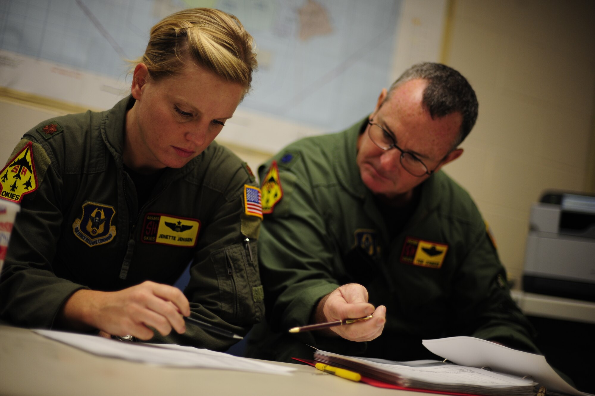 U.S. Air Force Maj. Jenette Jensen (left) and Lt. Col Daryl Humphrey, both KC-135 Stratotanker pilots assigned to the 465th Air Refueling Squadron, Tinker Air Force Base, Okla., review flight information before a refueling mission during exercise Rim of the Pacific (RIMPAC) at Joint Base Pearl Harbor Hickam, Hawaii, July 9, 2010.  during exercise Rim of the Pacific (RIMPAC) at Joint Base Pearl Harbor Hickam, Hawaii, July 9, 2010.  RIMPAC 2010 is the 22nd in a series of significant international combined/joint military exercises scheduled biennially by U.S. Pacific Fleet and takes place in the Hawaiian operating area.  RIMPAC training operations include participation by more than 14 nations, 34 ships, five submarines, more than 100 aircraft, and more than 20,000 Soldiers, Sailors, Marines and Airmen.  Multilateral exercises such as RIMPAC enhance cooperation between partnering nations and provide a unique opportunity to practice the ability to plan, communicate, and execute operations.  (U.S. Air Force photo by Tech. Sgt. Jacob N. Bailey/Released)

