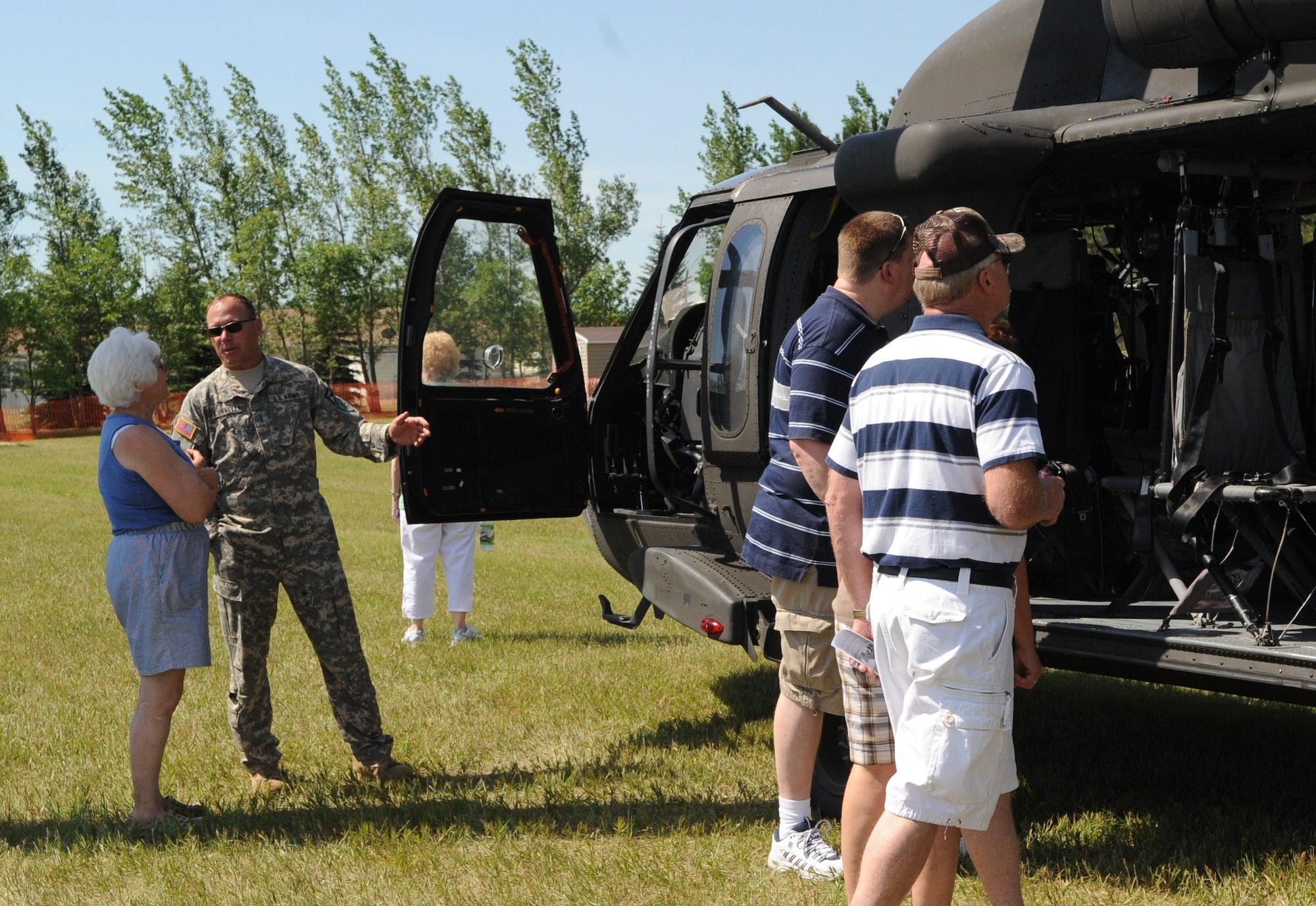 Members of the North Dakota National Guard explain the UH-60 Black Hawk helicopter to attendees of the Cavalier Air Force Station open house July 10. The UH-60 Black Hawk is capable of holding 15 passengers and carrying a maximum weight of 22,000 pounds. The open was held as a way for people within the local community to learn about the mission and capabilities of Cavalier AFS as well as the Air Force and military in general. (U.S. Air Force photo by 1st Lt. Anastasia Wasem) 