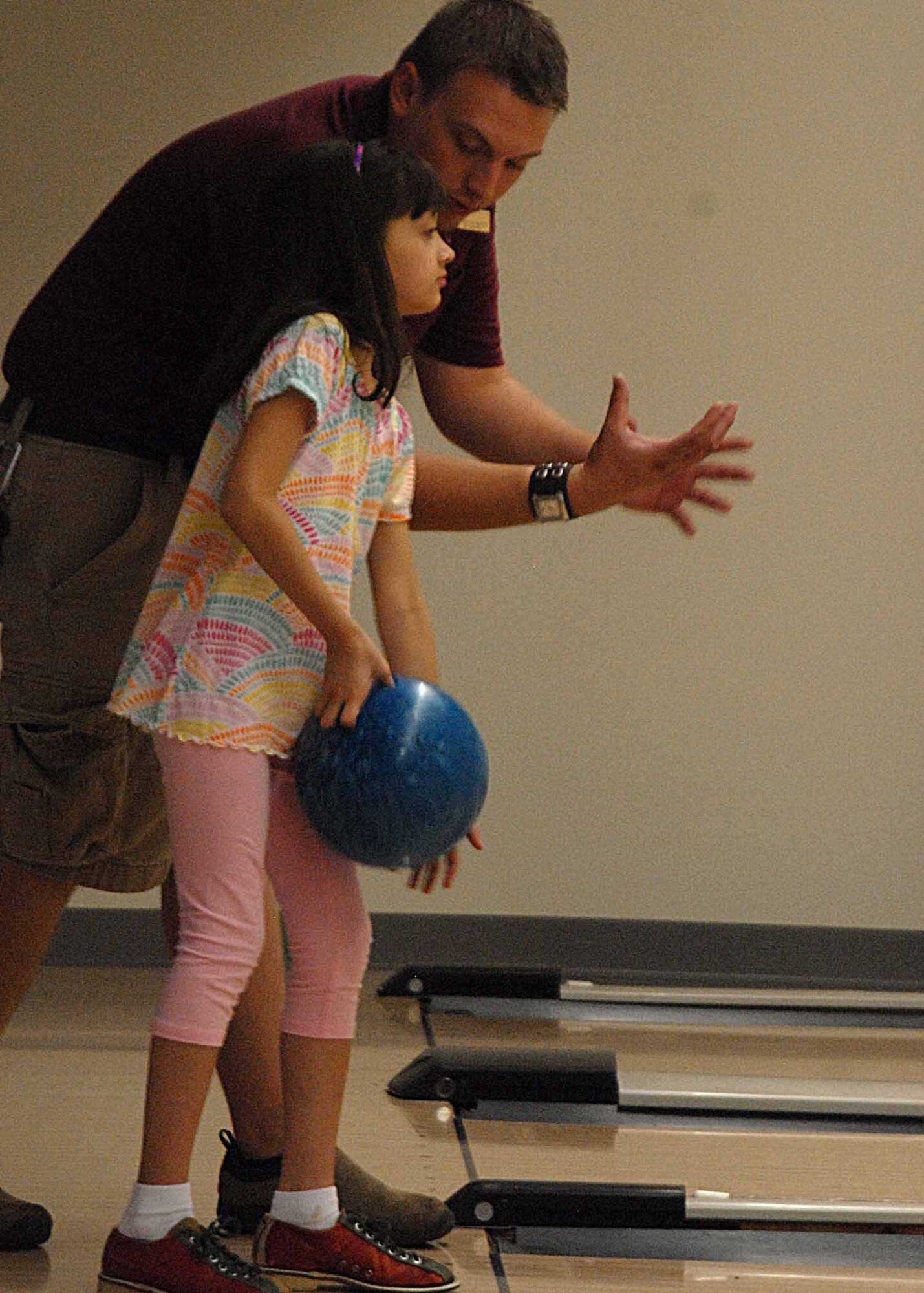 Alexianeria Gaud, 9, recieves bowling tips from Nicholas Gillett, 17th Force Support Squadron recreational aid assistant, during a Sizzlin' Summer Super Bowl workshop at the Thede Bowling Center, July 13. Eight youth ages 7 to 14 attended, to learn how to bowl from a United States Bowling Congress certified instructor. More than 19 youth signed up for the workshop, which ends Friday. (U.S. Air Force photo/ Senior Airman Tong Duong)