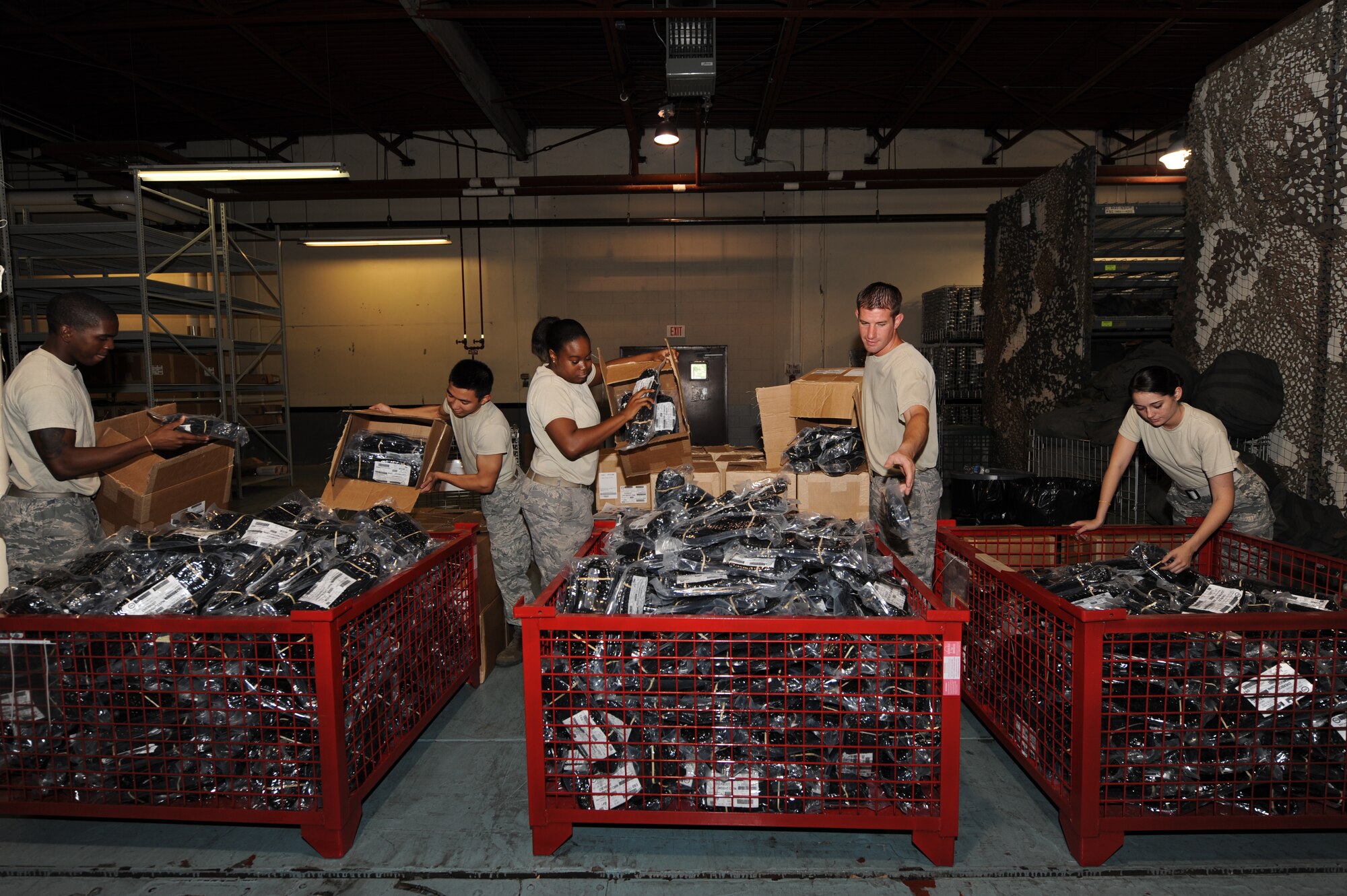 SEYMOUR JOHNSON AIR FORCE BASE, N.C. -- Airmen from the 4th Logistic Readiness Squadron disseminate boots for easy distribution to Airmen during the upcoming operational readiness exercise here July 9, 2010. During the exercise, Airmen will process through the 4th LRS to receive their Charlie bags, which contain two pairs of boots, four pairs of gloves with inserts, two pairs of chemical suits, a canister, first aid kit, M-8 paper and M-9 tape. (U.S. Air Force photo/Staff Sgt. Courtney Richardson)