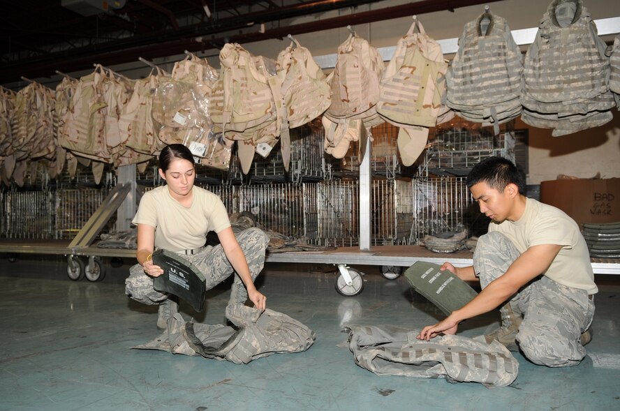 SEYMOUR JOHNSON AIR FORCE BASE, N.C. -- Airmen 1st Class Marti Scalf and Ralph Santos insert Kevlar plates into flak vests during an individual protective equipment inspection here July 9, 2010. Prior to use, the 4th Logistic Readiness Squadron check all vests and plates for anything rendering it unserviceable such as tears, loose stitching, holes and cracks. Airmen Scalf and Santos are both IPE journeymen from the 4th LRS. Airman Scalf is from Hartsfield, S.C., and Airman Santos hails from Waldorf, Md. (U.S. Air Force photo/ Staff Sgt. Courtney Richardson)(RELEASED)