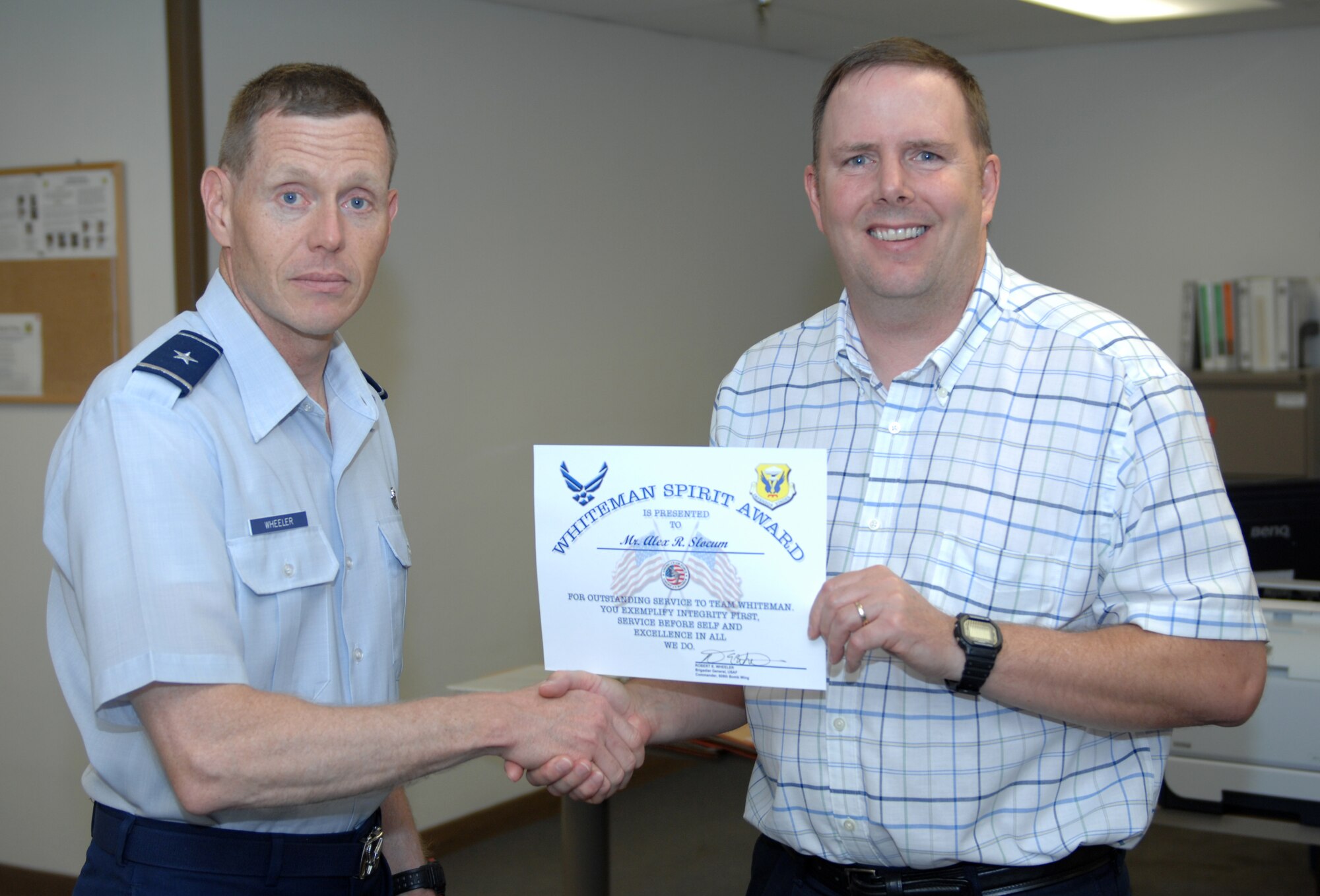 WHITEMAN AIR FORCE BASE, Mo. - The 509th Bomb Wing commander, Brig. Gen. Robert Wheeler, presents Alex Slocum, 509th BW information protection specialist, with the Whiteman Spirit Award July 12. (U.S. Air Force photo by Airman 1st Class Cody H. Ramirez)