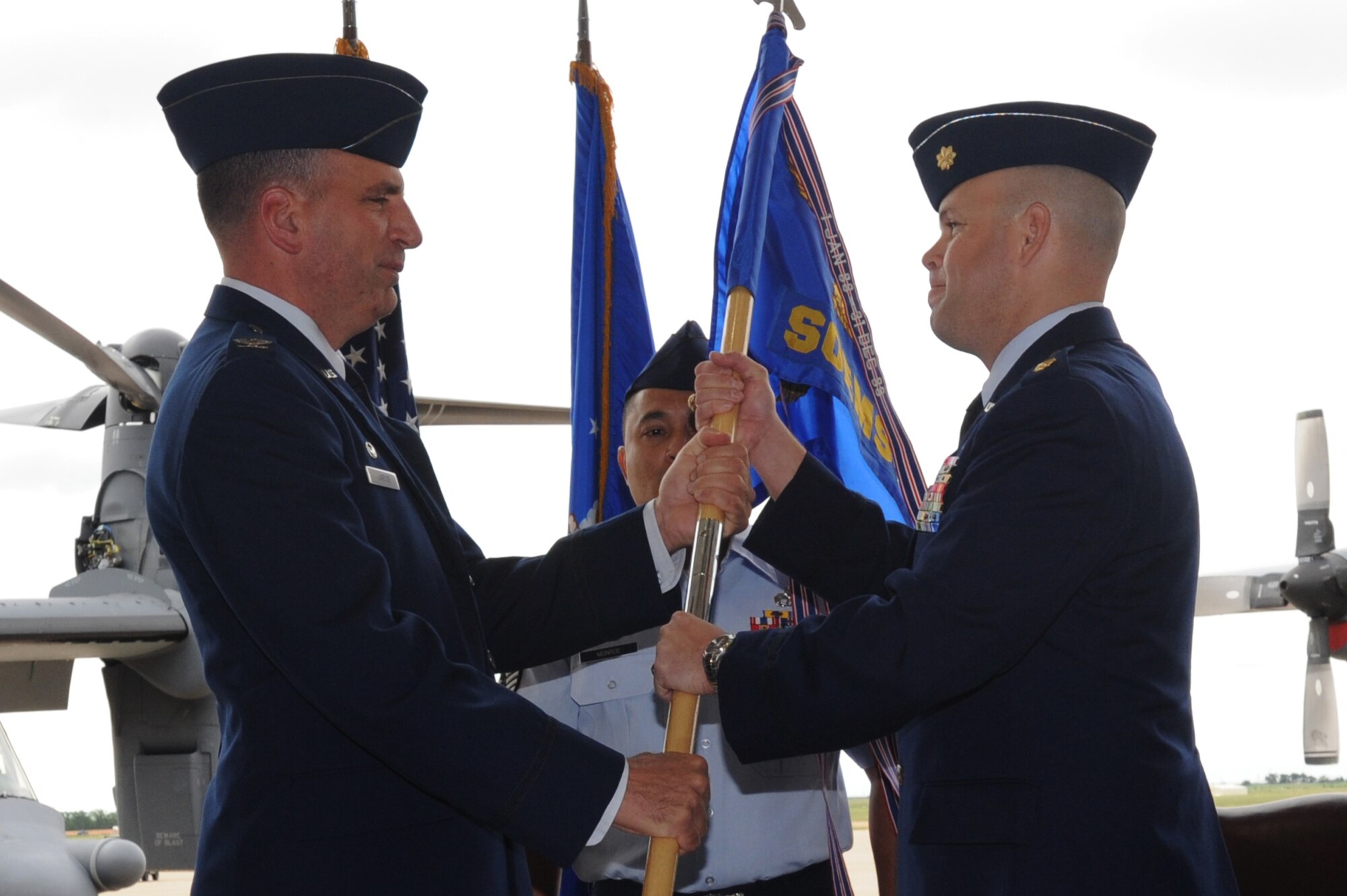 U.S. Air Force Col. Mark LaRose (left), 27th Special Operations Maintenance Group commander, hands the 27th Special Operations Equipment Maintenance Squadron (27th SOEMS) guidon to  U.S. Air Force Maj. John Baquet (right), 27th SOEMS incomming commander at Cannon AFB, N.M., 8 July 2010.  The change of command ceremony is a time-honored tradition that allows the unit to witness the old commanders relinquish their position and for new commanders to assume their roles over the squadron. (U.S. Air Force photo by Airman First Class Maynelinne De La Cruz)(Released)
