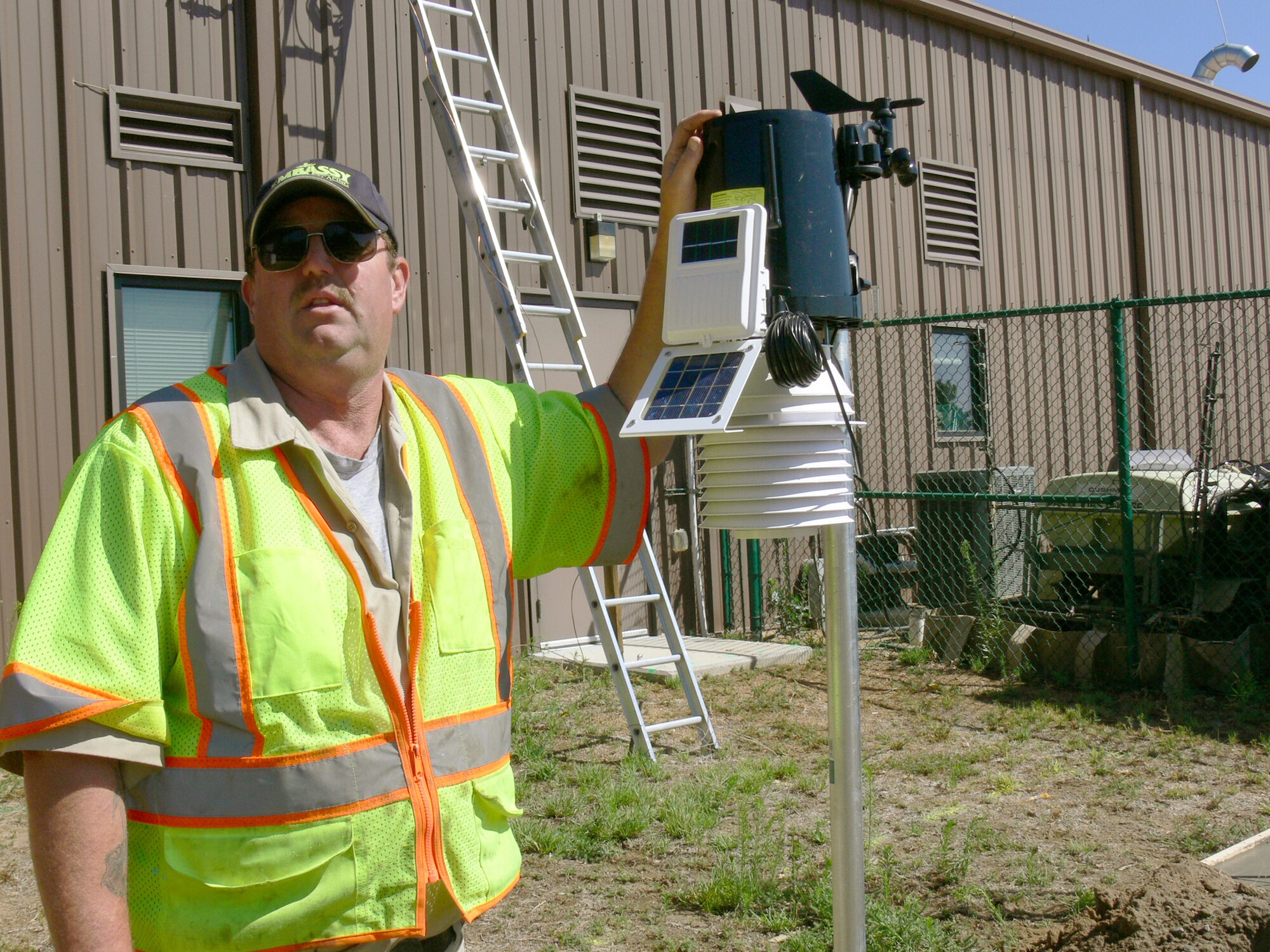 Rich Paquette explains the newly installed weather system tied directly to a central irrigation system. When there is an eighth of an inch of rain, the weather system tells the irrigation system to shut down. The new system is expected to reduce water used for irrigation at Peterson Air Force Base, Colo., by 50 percent. Mr. Paquette is from Embassy Lawn and Landscape, the head of irrigation at Peterson AFB. (U.S. Air Force photo/Monica Mendoza)