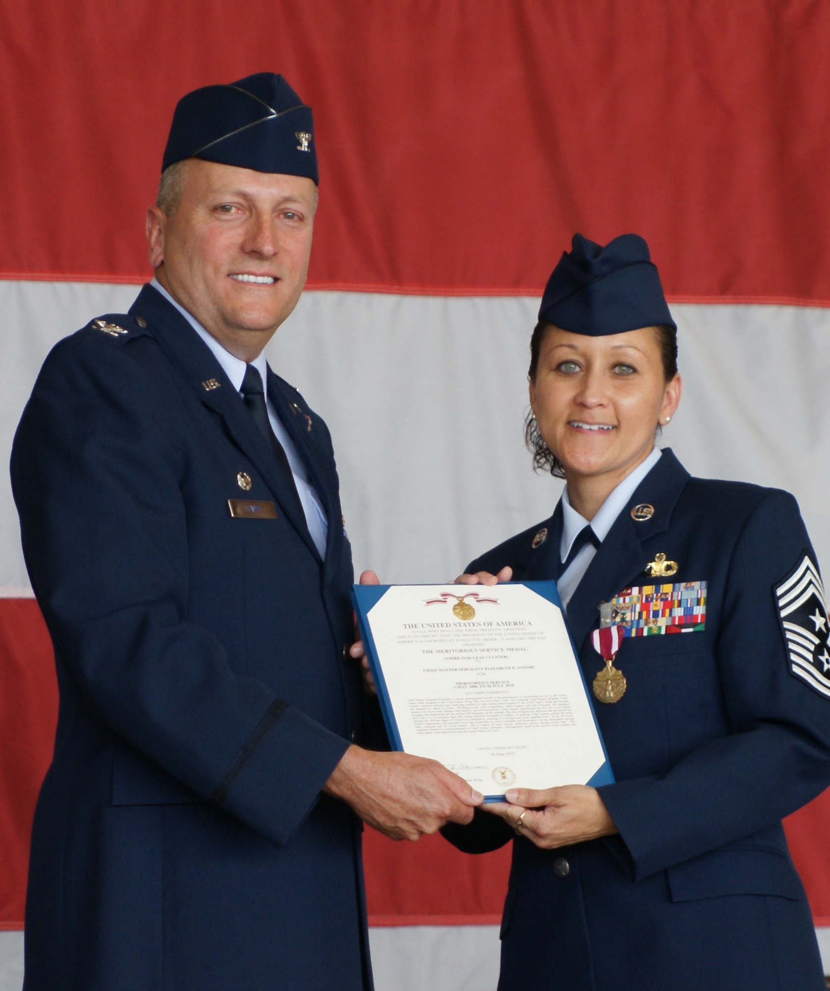 Chief Master Sgt. Elizabeth Atismé, 419th Fighter Wing Command Chief, receives a Meritorious Service Medal from 419th Commander Col. Walter “Buck” Sams during the chief’s retirement ceremony Sunday. Chief Atismé served as the 419th command chief for four years. (U.S. Air Force photo/Staff Sgt. Alan Schultz) 