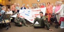 Members of the Kittyhawk Airlift Tanker Association receive a flag from residents of The Pines in appreciation of their time and service. (USAF Photo by SSgt. Terrica Y.Jones 916ARW/PA)
