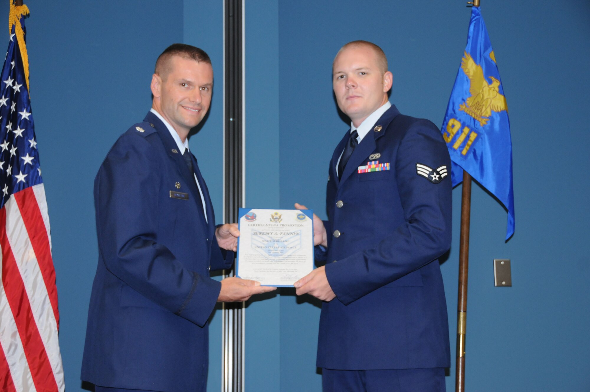 Newly promoted Staff Sgt. Jeremy Fannin displays his promotion certificate alongside Lt. Col. Bruce Heseltine. Both are members of the 911th Air Refueling Squadron. (USAF photo by SSgt. Terrica Jones, 916ARW/PA)