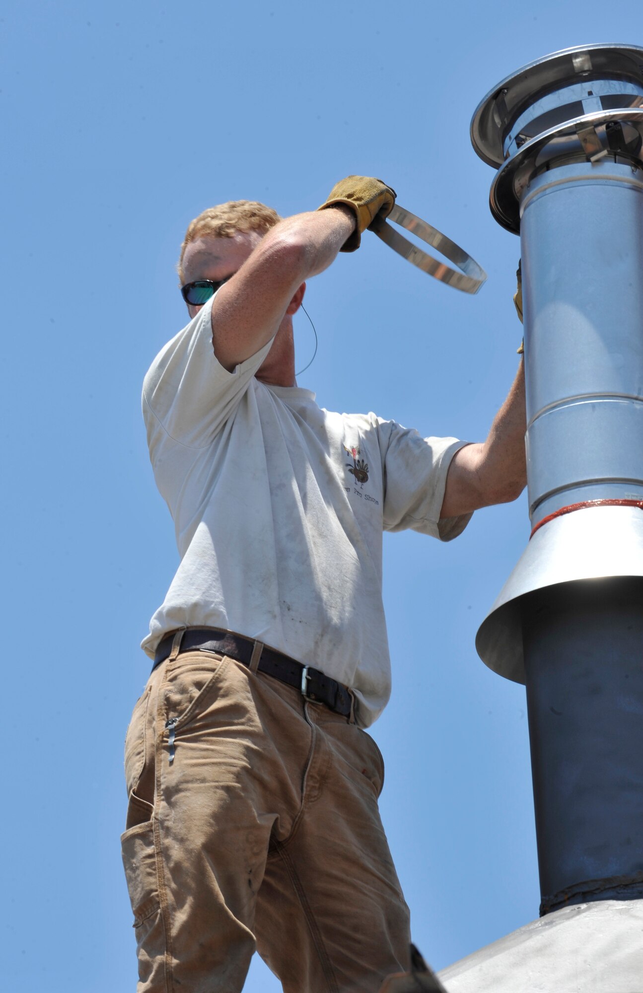 MOODY AIR FORCE BASE, Ga.-- Chris Gaskins, 23rd Civil Engineer Squadron heating, ventilation, air conditioning and refrigeration technician, wipes the sweat from his face while installing a new boiler stack on a roof top here July 7. The HVAC/R shop Airmen work in many extreme temperature conditions including roof tops, mechanical rooms and attics. (U.S. Air Force photo by Staff Sgt. Schelli Jones/RELEASED)