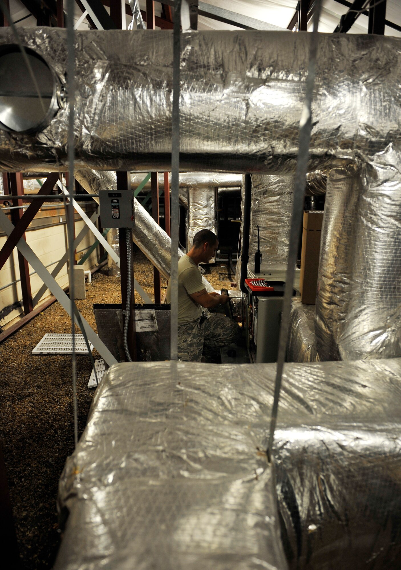 MOODY AIR FORCE BASE, Ga.-- Senior Airman Steven Kindle, 23rd Civil Engineer Squadron heating, ventilation, air conditioning and refrigeration journeyman, performs routine maintenance in the attic of the Jason D. Cunningham Airman Leadership School here July 7. The HVAC/R shop performs recurring maintenance to every HVAC system on base, completing large-scale work orders where they either install brand new systems or completely replace an existing one. (U.S. Air Force photo by Staff Sgt. Schelli Jones/RELEASED)