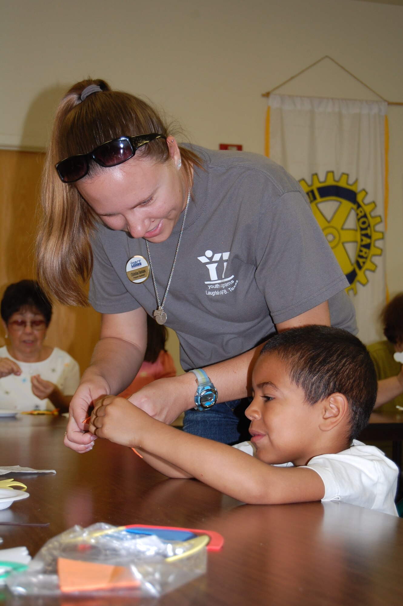 LAUGHLIN AIR FORCE BASE, Texas – Christie Santana, 47th Force Support Squadron, assists Deon, a Laughlin School Age participant, in punching out pieces of foam for an arts and crafts project at Del Rio Rotary Village July 8. Laughlin School Age participants completed projects with residents of the Del Rio Rotary Village as part of their community service curriculum. (U.S. Air Force Photo by Staff Sgt. Desiree Economides)