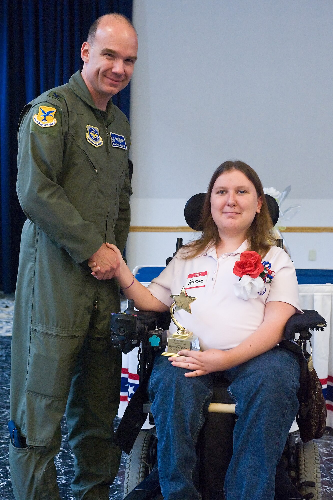 Col. Mason Morris, 436th Airlift Wing commander, shakes hands with Cassandra Manchester, Exceptional Family Member Program award winner, Dover Air Force Base, Del., July 6, 2010.  Ms. Manchester has volunteered more than 1,000 hours of community service in programs such as Go Green, Adopt A highway, Habitat of Humanity and numerous fund raising events.   (U.S. Air Force photo by Roland Balik/Released)